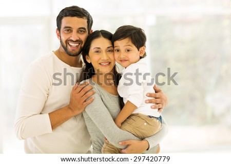 portrait of happy indian family of three standing indoors