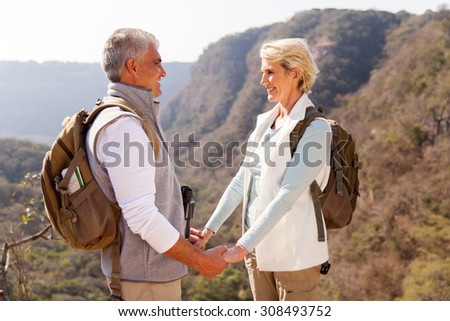 loving middle aged couple holding hands in mountain