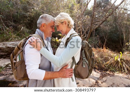 romantic senior couple hugging in forest