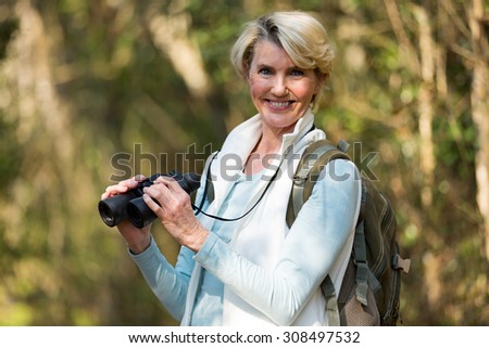 portrait of beautiful female hiker with binoculars