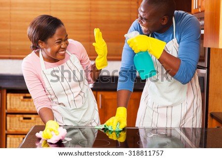 young african couple having fun while doing household chores