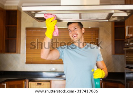 happy young man cleaning kitchen