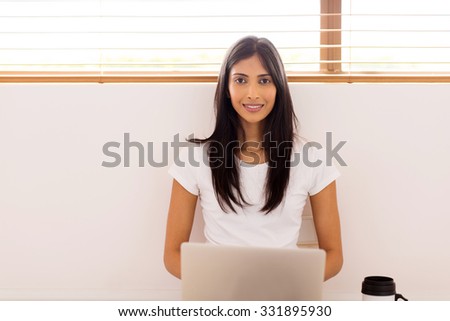 happy indian woman using laptop computer at home