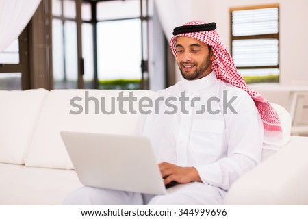 modern young arabian man using laptop computer at home