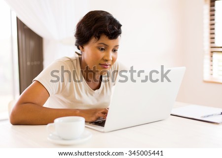beautiful african american woman looking at laptop screen