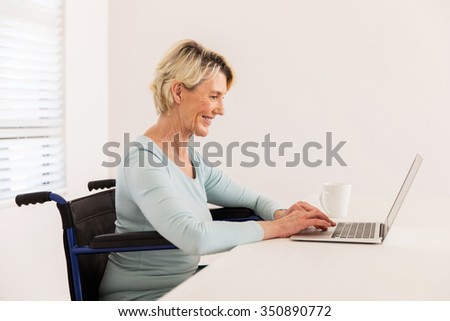happy disabled senior woman looking at laptop screen