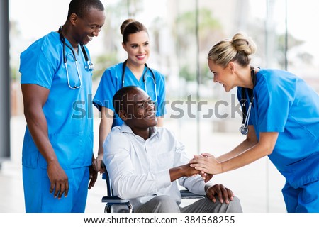 happy female doctor greeting disabled patient in hospital