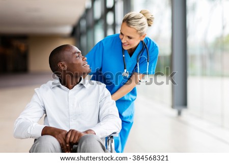 caring female nurse talking to disabled patient in hospital