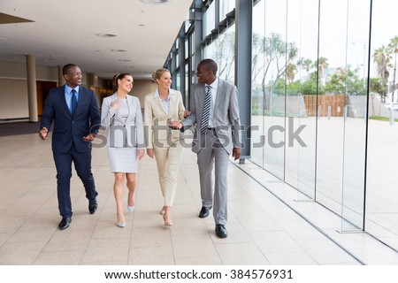 group of professional businesspeople walking in office building
