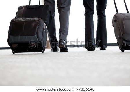 business travellers walking in airport with luggage