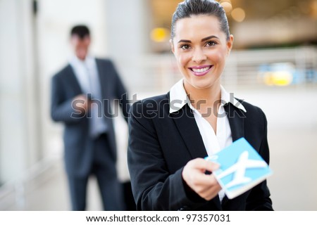 attractive businesswoman handing over air ticket at airport check in counter