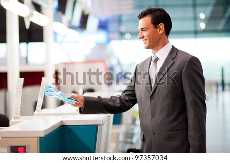 handsome businessman handing over air ticket at airline check in counter
