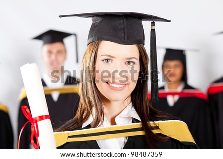 beautiful female university student at graduation with classmates