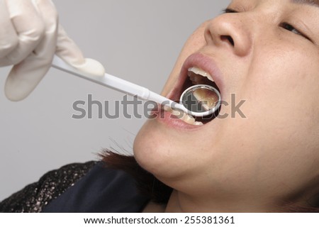 Woman has checking tooth and mouth by dental mirror