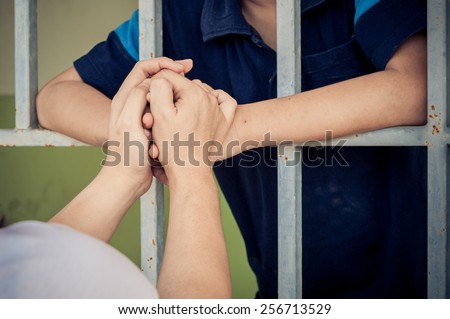 Mom hand holding young kid at the back of the iron bar