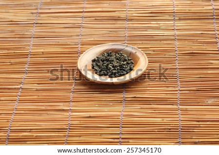 Dry herb tea on wood plate and grass mat