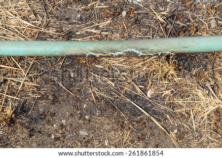 The old crack blue pipe on the dirty burn ground