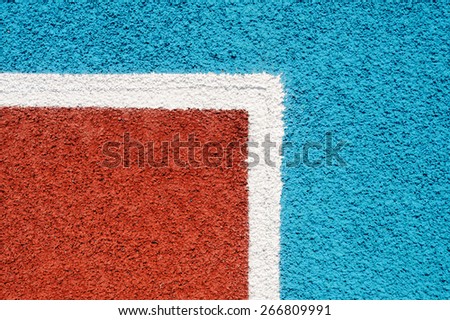 Running track made from red and blue granule rubber and white corner