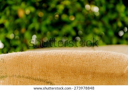 Thin focus old brown ramie sac with green leaf background