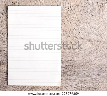 The old page ripped off from the notebook on white fur cow skin