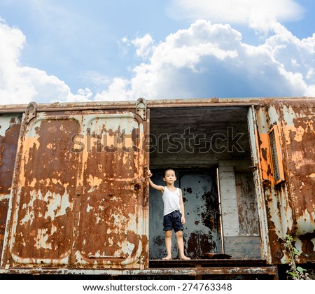 The lonely boy in white vest the old train room looking to outside