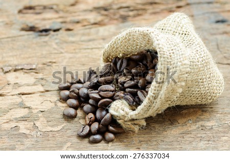 Close up thin focus on Coffee bean in bag on grunge wood table