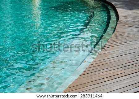Thin focus on dirty and wet Wood floor beside the green water pool