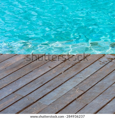 Thin focus on Wood floor beside the green water pool