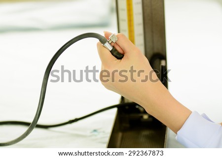 Close up thin focus to blur face of young female doctor hand in white uniform pump blood pressure meter