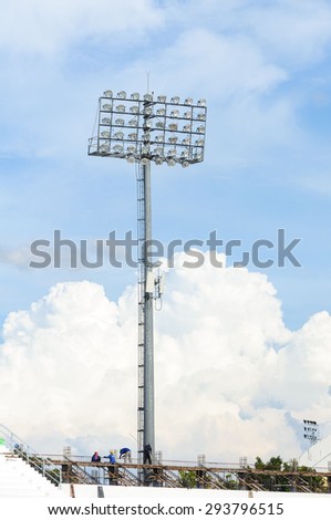 Worker construct Big and tall stadium spot light under blue sky white cloud