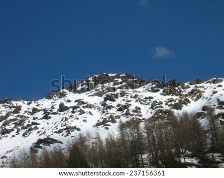 Mountain snowy peaks of the Alps on Spring. Red rocks (iron inside). Land for hiking, mountain running, mountaineering and other outdoor activities. Val Masino, Lombardy, Italy