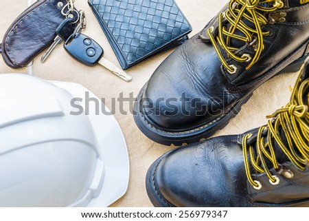 safety shoe and safety helmet,wallet,car Key on Brown Background