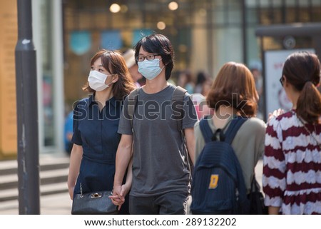 SEOUL, SOUTH KOREA - JUN 19, 2015: A tourist wearing a mask for protect from Mers virus in South Korea, at Seoul Market Myeong-dong Virus MERS, which has no known cure or vaccine.