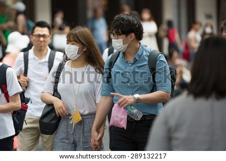 SEOUL, SOUTH KOREA - JUN 19, 2015: A tourist wearing a mask for protect from Mers virus in South Korea, at Seoul Market Myeong-dong Virus MERS, which has no known cure or vaccine.