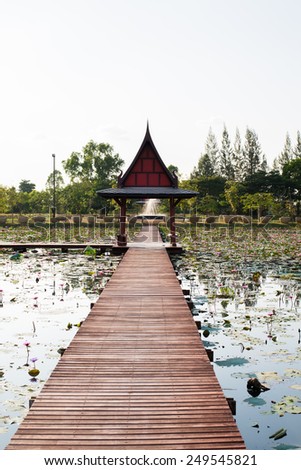 Thai wood lake pavilion cottage and wooden bridge around with lotus flower and green leaf