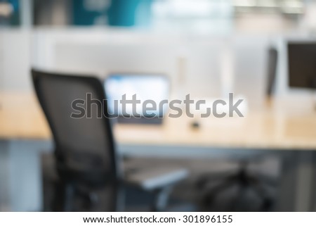 Abstract office blur background with wooden desk, chair with laptop/pc and display