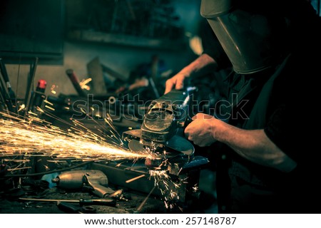 Metal grinding on steel spare part in workshop