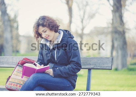 Young girl writing in daily journals at park