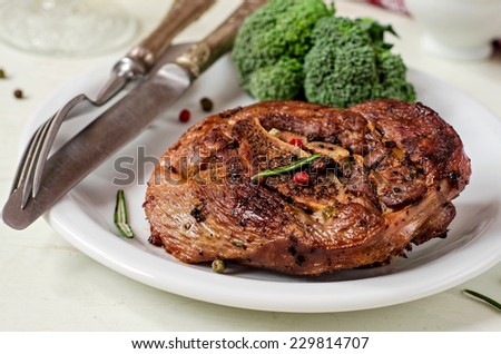 Grilled turkey steak in white plate on white wooden background