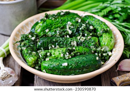 Pickles with garlic and crushed greens in clay bowl