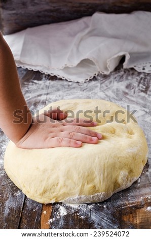 Children hand knead dough on wooden vintage table