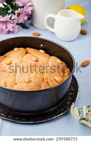 Basbousa (namoora) - arabian semolina cake with almonds and honey syrup on cotton background