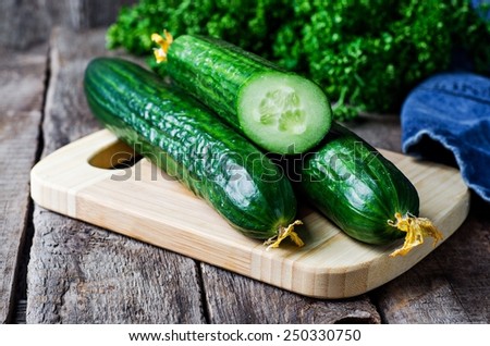 Cucumber on wooden plate and vintage background. Selective focus on cucumber