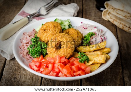 Vegetarian Falafel - fried balls with crushed vegetables and potatoes in whitw plate on wooden background. East cuisine