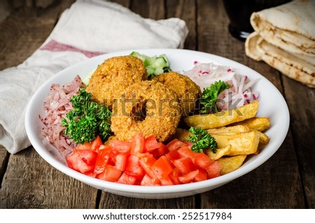 Vegetarian Falafel - fried balls with crushed vegetables and potatoes in whitw plate on wooden background. East cuisine