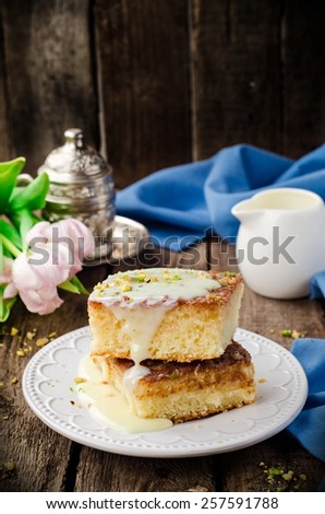 Basbousa (namoora or revane) - semolina cake with condensed milk on wooden background
