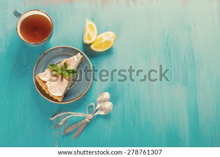 Piece of fresh homemade lemon meringue tart on the blue wooden table, selective focus. Top view