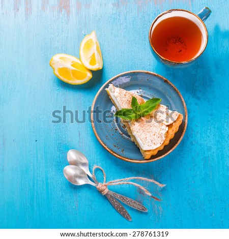 Piece of fresh homemade lemon meringue tart on the blue wooden table, selective focus. Top view