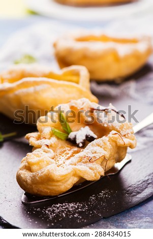 Delicious hot dessert: baked pears in pastry on rustic wooden background. Selective focus
