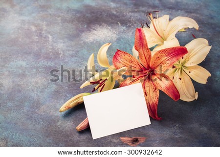 Bunch of orange and yellow lilly flowers on vintage blue background. Space for text. Greeting card. Selective focus